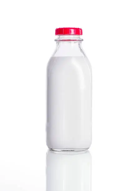 Photo of Fresh glass bottle of milk with a red lid