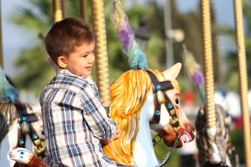 Child Having Fun on the Carousel.