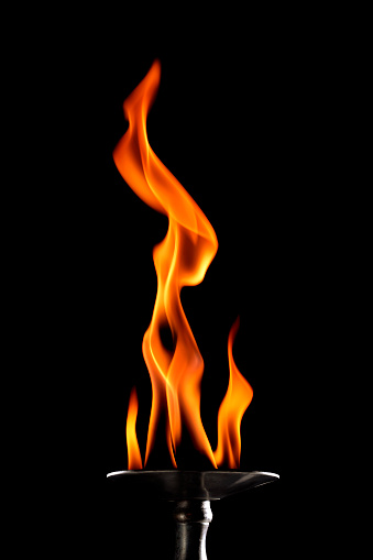 Stack of thermal energy close-up, red and yellow, heat energy igniting fuel during night/light on black background.