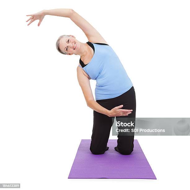 Anziani Donna Stretching Al Braccio Oltre Il Tappetino Da Yoga - Fotografie stock e altre immagini di Abbigliamento sportivo