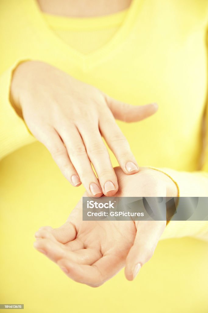 Detail of a young woman applying cream to her hands "Close-up of a young female applying cream to her hands, Front view" Palm of Hand Stock Photo
