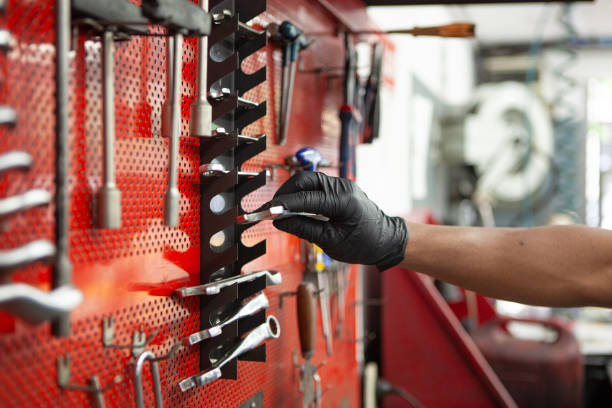 Unidentified person's hand placing wrench on tool pegboard