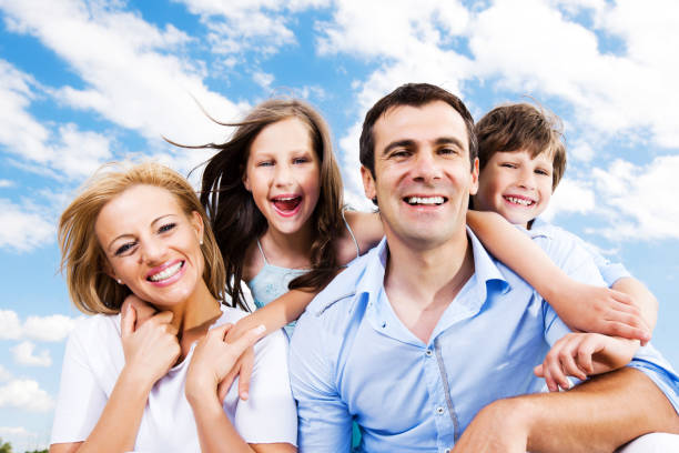 istock Smiling family against the sky and clouds. 184614297