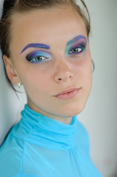 istock Young woman with strange disproportionate colorful eye shadow make-up 184614733