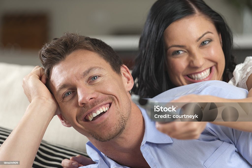 Excited пара смотреть телевизор, улыбается - Стоковые фото 20-24 года роялти-фри