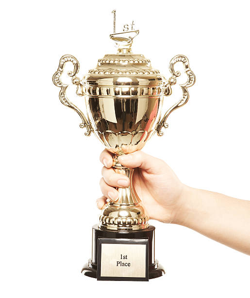 primer plano de una persona de éxito celebrando un trofeo contra blanco - effort gold indoors studio shot fotografías e imágenes de stock