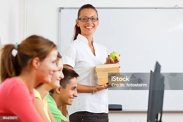 Profesor Sonriente Con Libros En La Computadora De La Clase Foto de stock y más banco de imágenes de Delante de