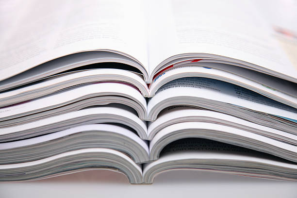 A bunch of open magazines stacked on top one another