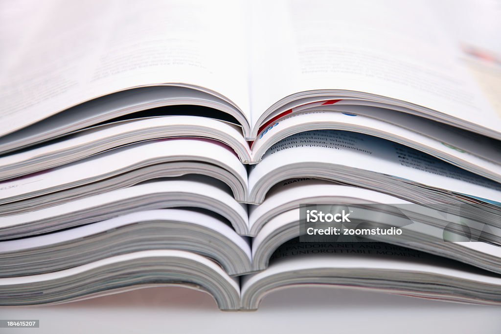 A bunch of open magazines stacked on top one another Magazines. See more:::: Magazine - Publication Stock Photo