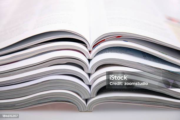 A Bunch Of Open Magazines Stacked On Top One Another Stock Photo - Download Image Now