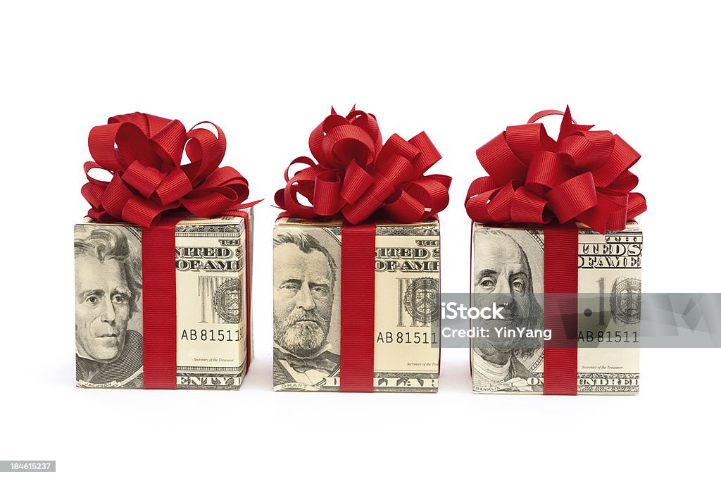 Money Gift—Bills Wrapped in Red Bow, Ribbon on White "Subject: Horizontal view of three square gift boxes, wrapped in twenty dollar, fifty dollar, and one hundred dollar United States currency bills and tied with red ribbons and bows. The bow color suggests a Christmas gift, bonus, birthday present, or special occasion. Isolated on a white background." Christmas Stock Photo