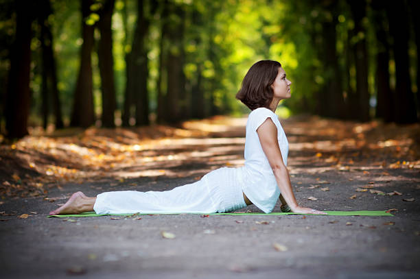 Practicing yoga in the forest, cobra pose "Beautiful young woman practicing yoga in the forest, yoga cobra position." forest cobra stock pictures, royalty-free photos & images