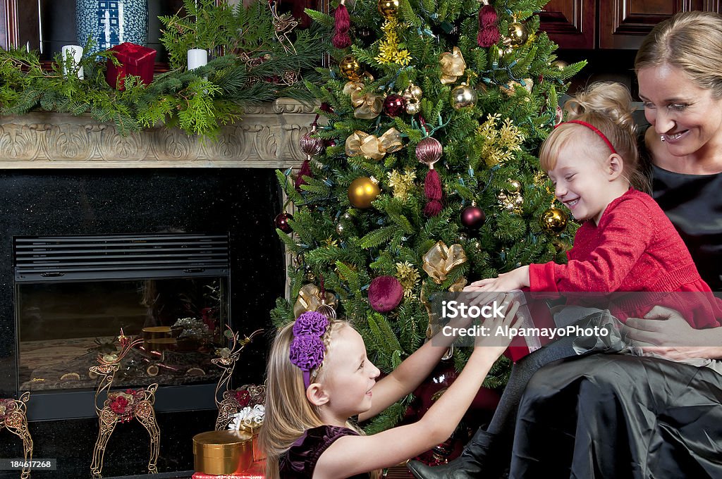 Mother and daughters opening gifts on a Christmas day (IV)  Adult Stock Photo