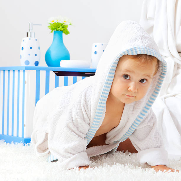 istock Baby Girl Wearing Bathrobe Crawling on the carpet 184617663