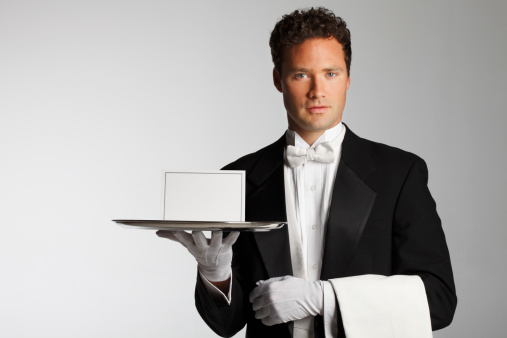 A butler or a waiter carrying a blank invitation on a silver platter.
