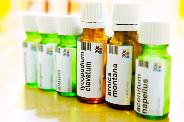 Homeopathic Medicine: Remedies Closeup of bottles with homeopathic remedies, arnica montana, aconite napellus, lycopodium clavatum … Generic labels with generic names created by me and applied to bottles. lycopodiaceae photos stock pictures, royalty-free photos & images