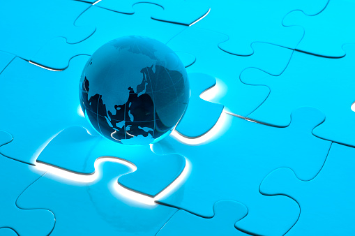 Global Business solution concept with blue globe on a glowing jigsaw puzzle piece showing Asia