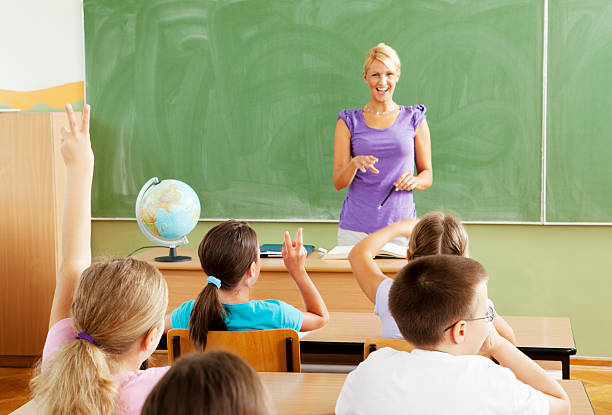 istock Female Teacher Questioning little students 184618711