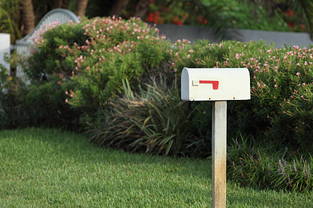 mail box white metal mail box in front of a house.  mailbox stock pictures, royalty-free photos & images