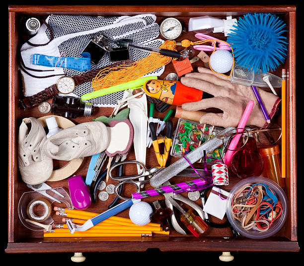 Junk Drawer with many miscellaneous objects Junk Drawer with miscellaneous objects, Including, Baby Shoes Elastic Bands, Pencils, Compass, New Years Eve Party Blower, Fake Hand, Cellophane Tape, and More. Image shot with, Canon 5D Mark2 , 100 ISO, 24-115mm lens and studio strobes. obsolete stock pictures, royalty-free photos & images