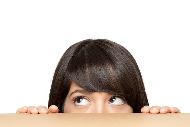 Think hiding . A teen girl hiding behind the box. looking around stock pictures, royalty-free photos & images