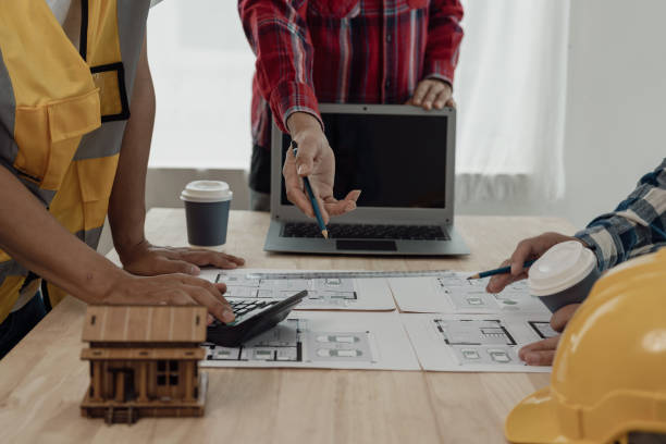 istock Construction engineers work on blueprints to build large commercial buildings with engineering tools and construction ideas for houses or office buildings in real estate. Close-up photo 1846206385