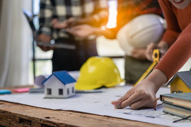 istock Construction engineers work on blueprints to build large commercial buildings with engineering tools and construction ideas for houses or office buildings in real estate. Close-up photo 1846207435