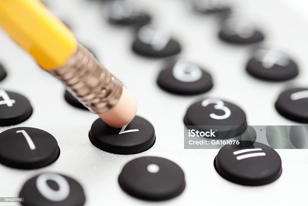 Pencil and calculator Pushing the button on a calculator Banking Stock Photo