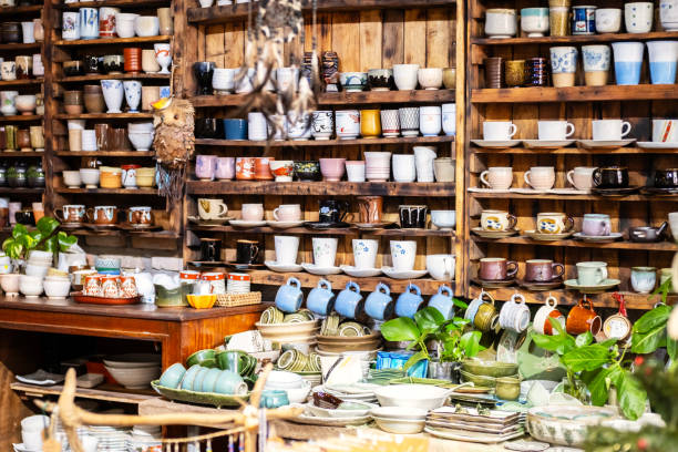 Small store with many pottery ceramic standing on shelves.