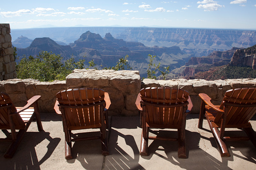 From a comfortable deck at the Grand Canyon Lodge, Adirondack chairs line the stone walls along the North Rim of the Grand Canyon National Park in Arizona. Built in 1927-28, the historic Grand Canyon Lodge is the only lodging inside the National Park on the North Rim. Located at Bright Angel Point, the Lodge was declared a National Historic Landmark in 1987