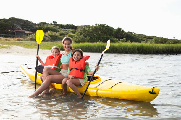 adolescente com meninas sentada no caiaque - summer camp child teenager kayak - fotografias e filmes do acervo