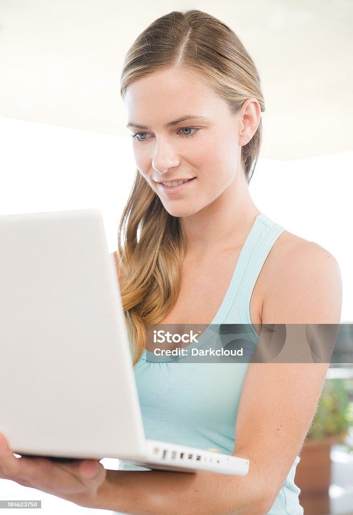 Bella donna utilizzando un computer portatile - Foto stock royalty-free di Abbigliamento casual