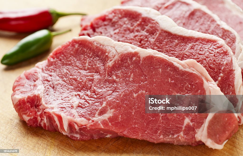 Slices of New York Strip Steak on cutting board Raw fresh cut New York Strip steak.  Please see my portfolio for other food images. Meat Stock Photo