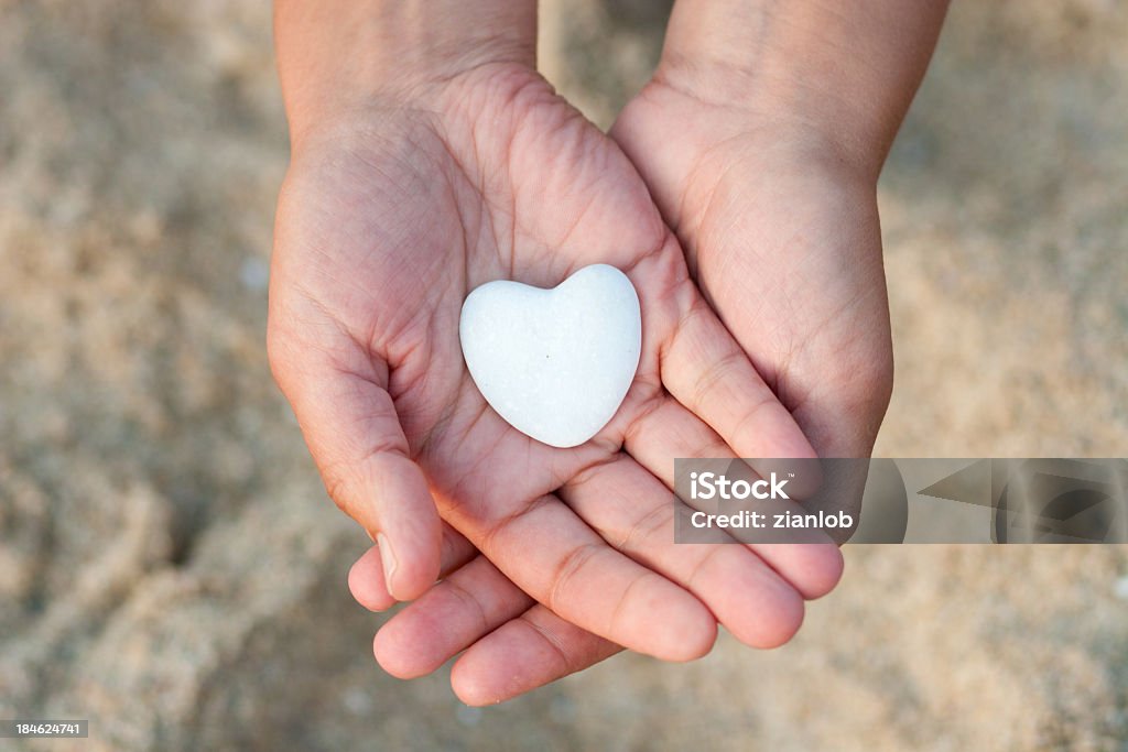 Mãos segurando um coração sobre fundo desfocado areia. - Royalty-free Símbolo do Coração Foto de stock