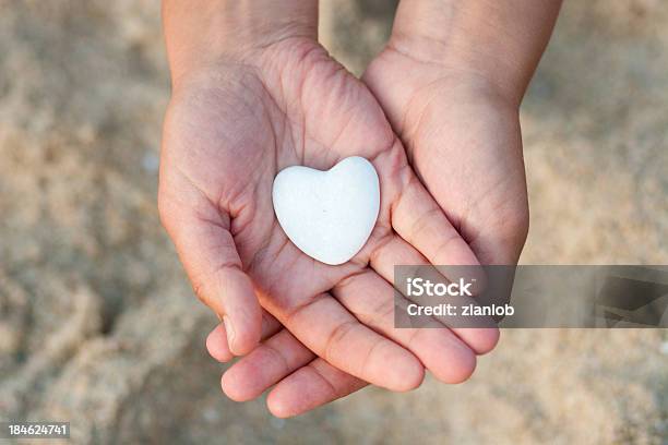 Mãos Segurando Um Coração Sobre Fundo Desfocado Areia - Fotografias de stock e mais imagens de Símbolo do Coração