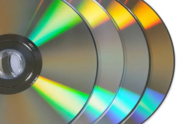 "A stack of 4 DVDs upside down showing the colorful, reflective, data surface. This photo was shot in the studio isolated on a white background."