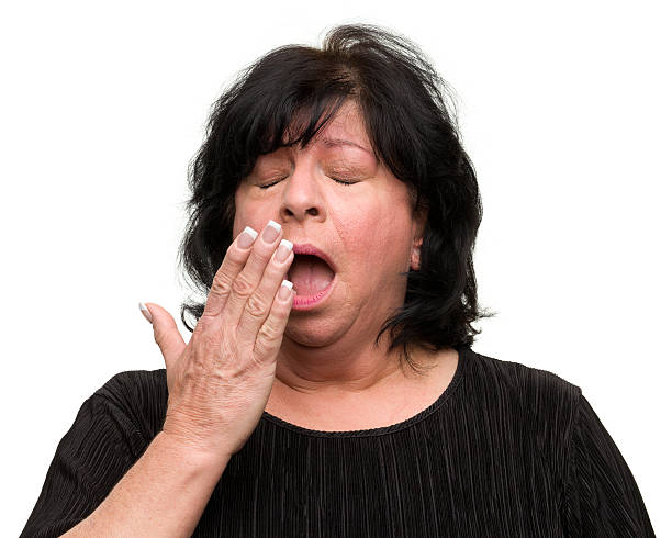 yawning woman - ogen dicht closeup vrouw 50 jaar stockfoto's en -beelden