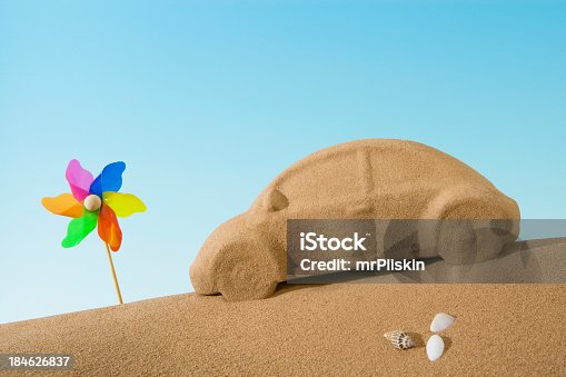 istock Sand sculpture of car beside toy windmill 184626837