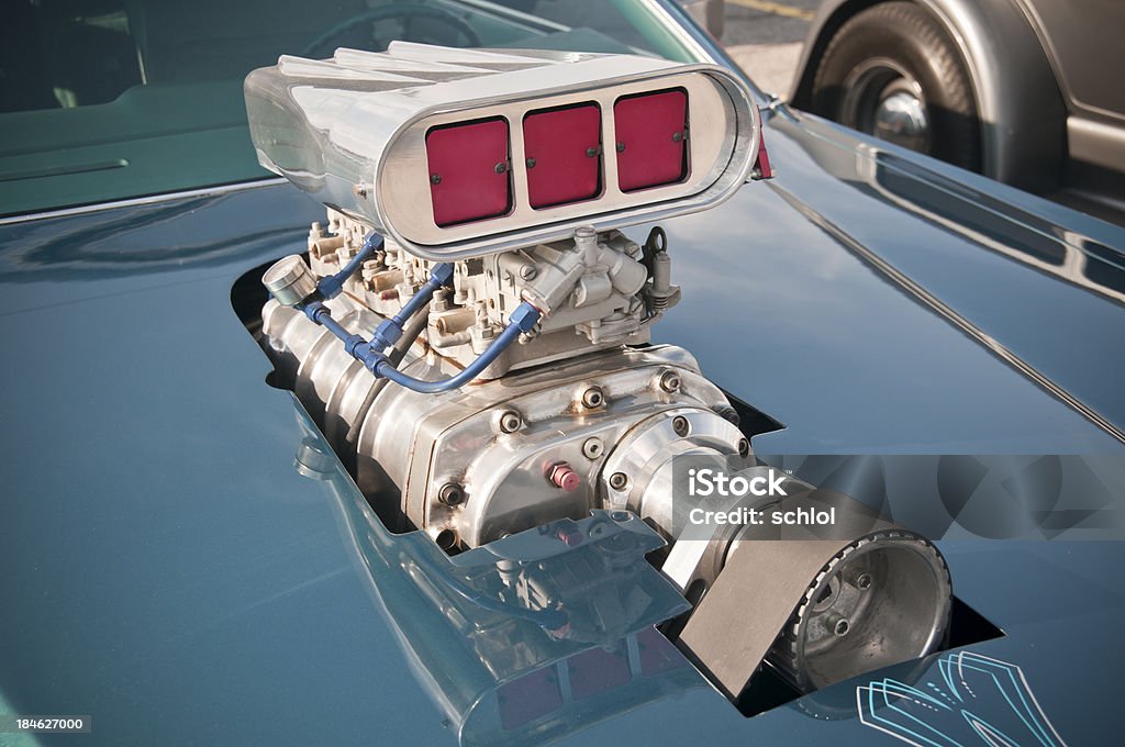 Supercharged Muscle Car Engine Supercharged engine poking through the hood of an old muscle car. Supercharged Engine Stock Photo