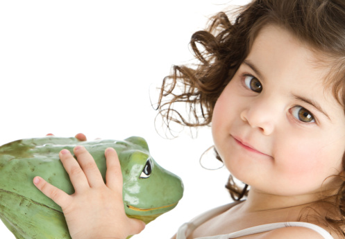 Adorable curly 2 years-old little girl with frog looking at camera