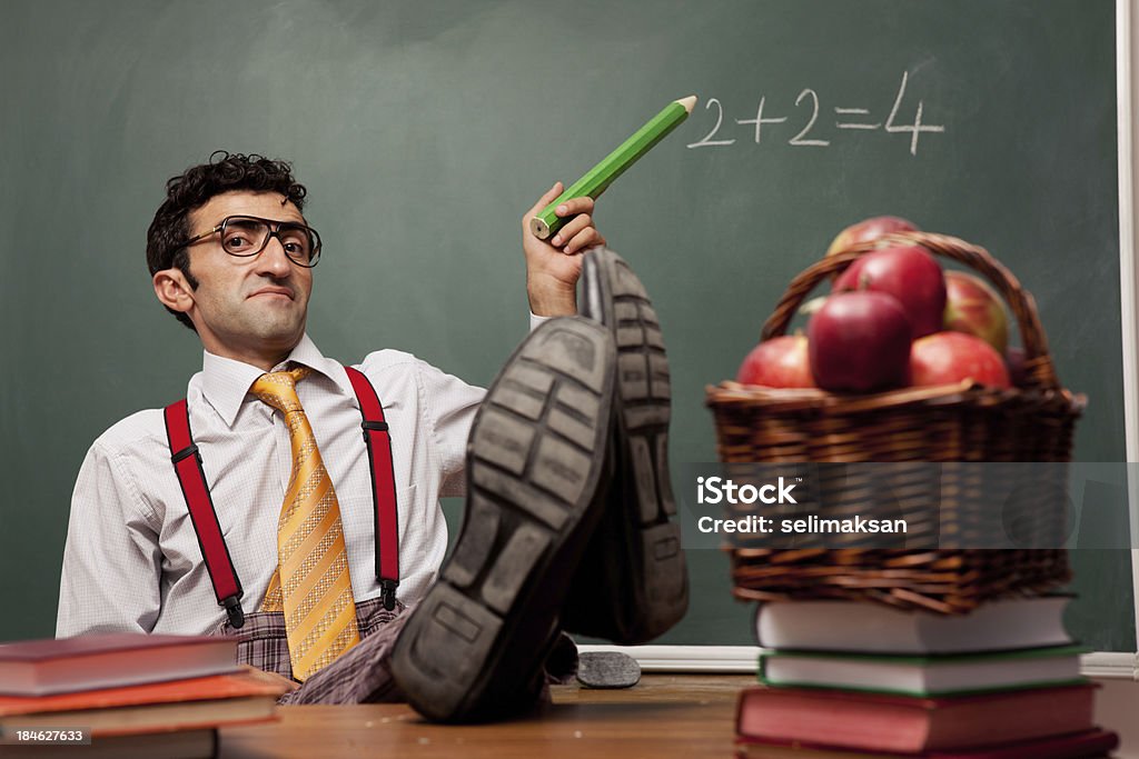 Prepotente insegnante seduto e insegnamento della matematica - Foto stock royalty-free di Insegnante
