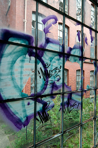 istock Broken window with graffiti in derelict factory 184627816
