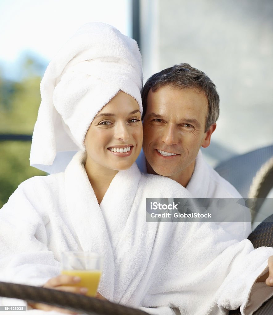 Coppia sorridente seduto all'aperto della spa - Foto stock royalty-free di Abbracciare una persona