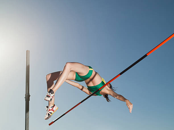 atleta de salto en la arena - salto de altura fotografías e imágenes de stock