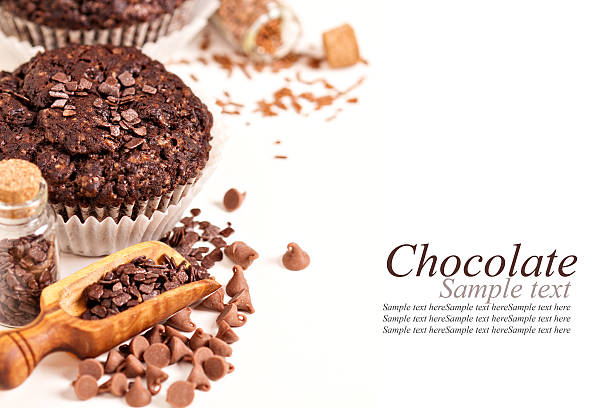 Muffins, chocolate drops and pieces on white
