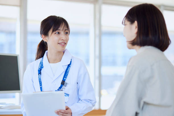 病院の診察室で女性患者を診察する女性医師 - 医者 ストックフォトと画像