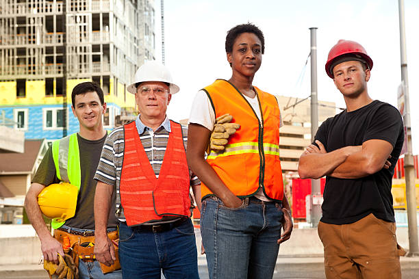 istock Four construction workers standing in front of a building site. 184636493