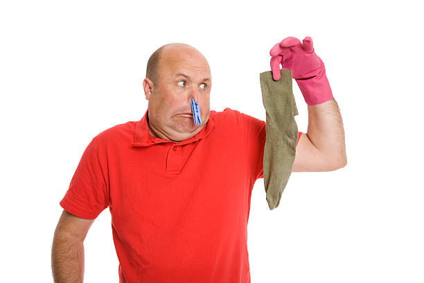 Smelly Sock A man holding a smelly sock -pegged nose! holding nose stock pictures, royalty-free photos & images