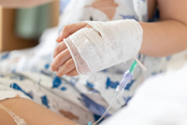Close up child hand with saline IV solution in hospital