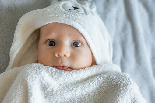 Adorable caucasian baby wearing bear towel bathrobe